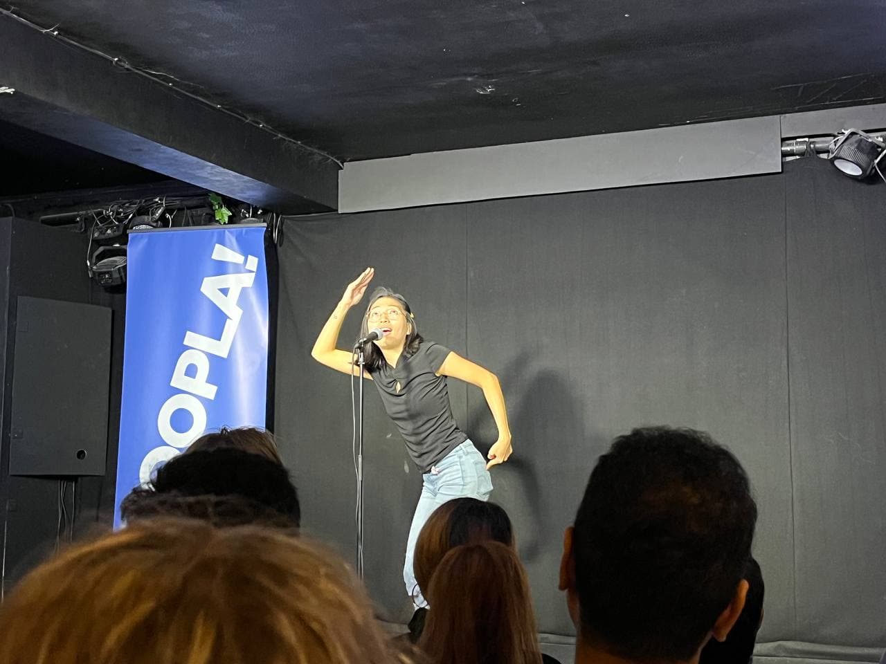 Hanny doing standup comedy in a pub